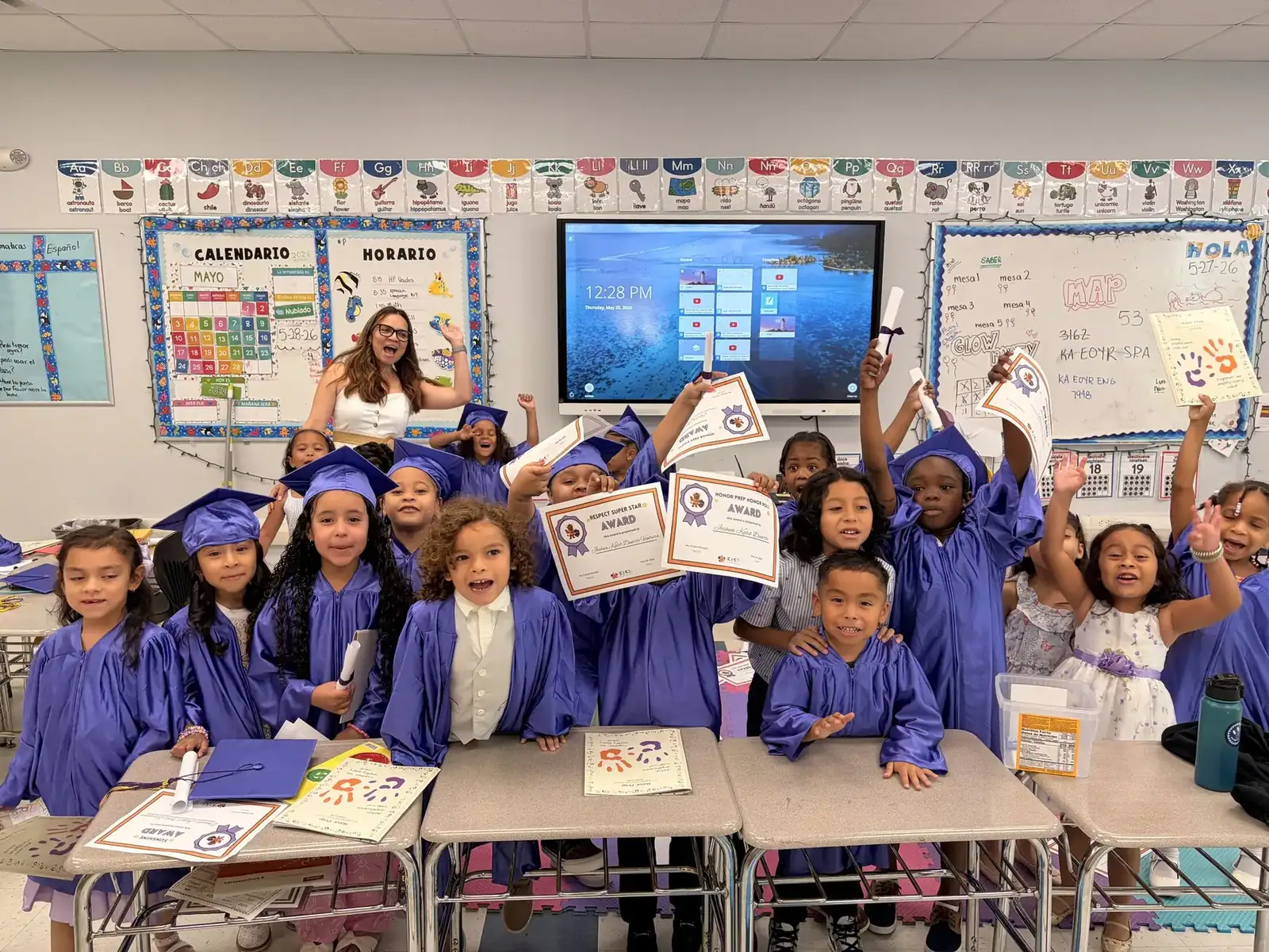 Honor Prep students in graduation caps holding certificates in their classroom