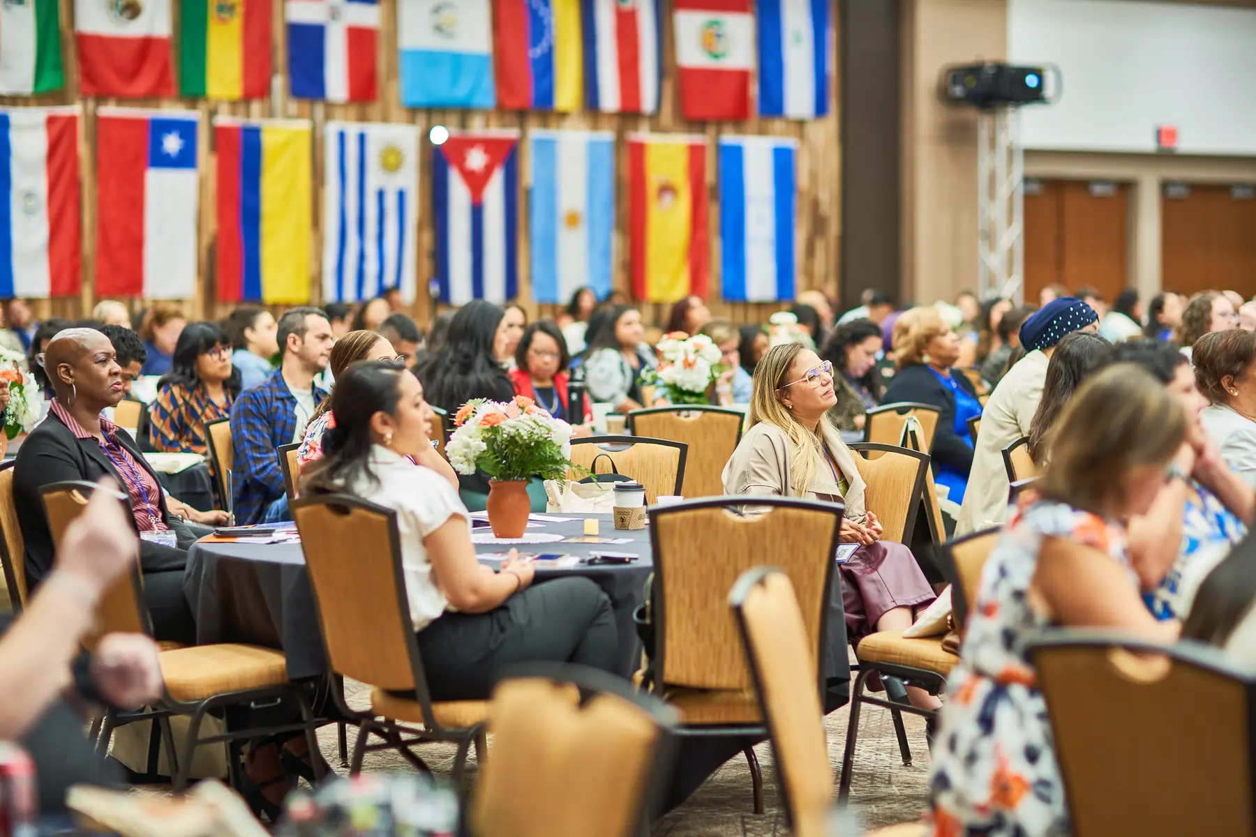 The Latine Education Summit: a full banquet hall seated under the flags of Latin American countries